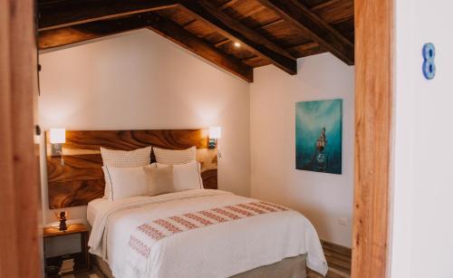 a bedroom with a large bed with a wooden headboard at Bärehuus Boutique Hotel in Antigua Guatemala