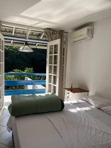 a bed in a room with a large window at Casa Cristo Redentor c/piscina in Rio de Janeiro