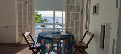 mesa con ordenador portátil en una habitación con ventana en Tambo Bombinhas en Bombinhas