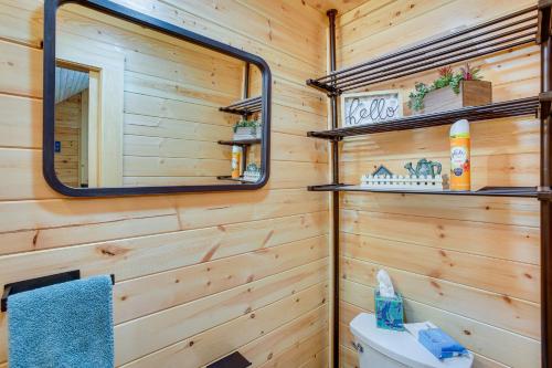 baño con paredes de madera, espejo y aseo en Celina Cabin with View of Dale Hollow Lake!, en Hilham