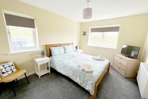 a bedroom with a bed and a tv and a chair at An Lochan in Manish