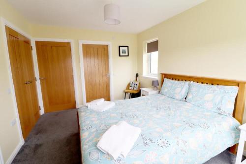 a bedroom with a bed with a blue comforter at An Lochan in Manish