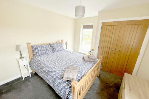 a bedroom with a bed with a blue and white comforter at An Lochan in Manish