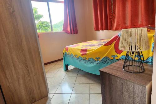 sypialnia z łóżkiem z kolorowym kocem w obiekcie Vaiana Home 2 - bord de lagon w mieście Taputapuapea