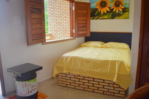 a bedroom with a brick bed and a window at Ap Standart - Pousada Flor da Serra - Mulungu in Mulungu