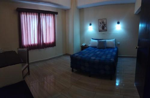 a bedroom with a bed and a red window at Hotel Sevilla in Guatemala