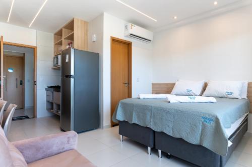 1 dormitorio con 1 cama grande y nevera en Makia114experience, en Porto de Galinhas
