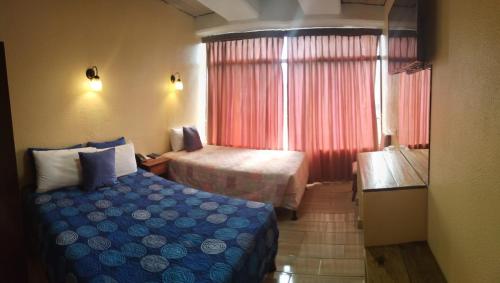 a hotel room with a bed and a window at Hotel Sevilla in Guatemala