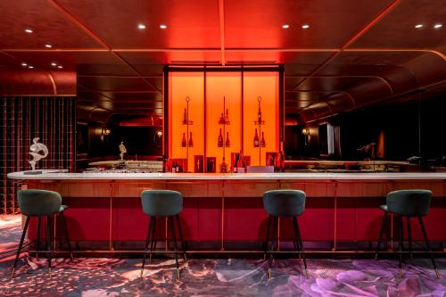 a bar in a room with chairs around it at voco Dubai Monaco, the Heart of Europe by IHG in Dubai