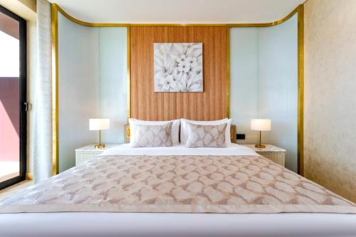 a bedroom with a large bed with two lamps at voco Dubai Monaco, the Heart of Europe by IHG in Dubai