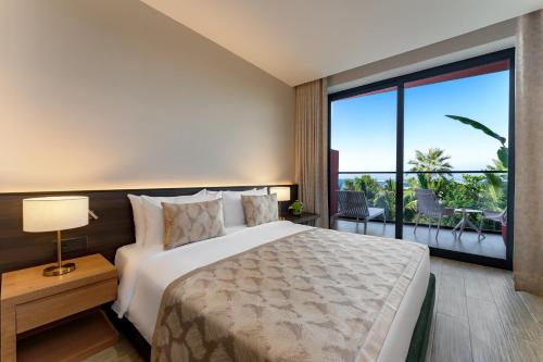 a bedroom with a large bed and a large window at voco Dubai Monaco, the Heart of Europe by IHG in Dubai