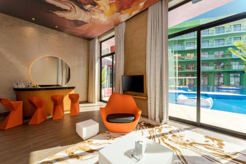 a living room with orange furniture and a large window at voco Dubai Monaco, the Heart of Europe by IHG in Dubai