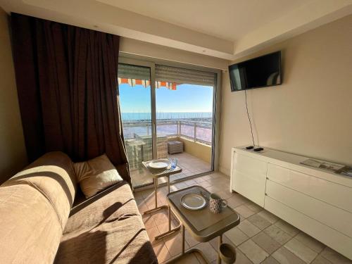 芒通的住宿－Superbe appartement en bord de mer, près du centre et des plages，一间卧室设有一张床和一个享有美景的大窗户