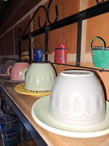 a shelf with plates and utensils on a table at Casa de Praia - meu lugar em Iriri in Anchieta