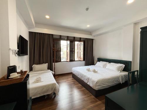 a hotel room with two beds and a desk at Mclane Boutique Hotel in George Town
