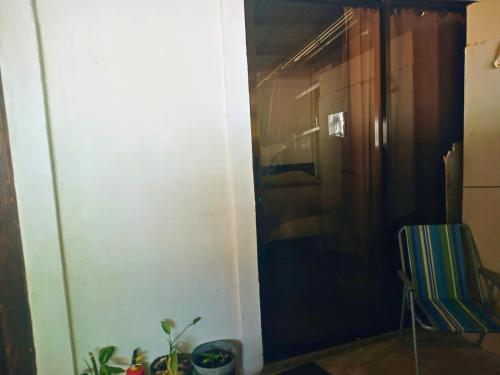 a hallway with a door and a chair in a room at Hogar tico-estadounidense cerca de aeropuerto in Alajuela City