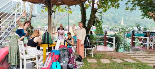 a group of people sitting at a table with backpacks at Carambola Bungalow in Phong Nha