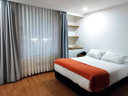 1 dormitorio con cama y ventana grande en Eurolan 93, en Bogotá