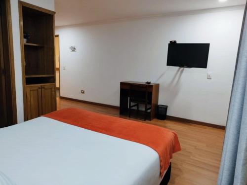 a bedroom with a bed and a flat screen tv at Eurolan 93 in Bogotá