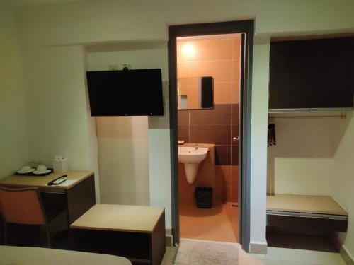 Baño pequeño con aseo y lavamanos en Jin Hotel, en Puchong