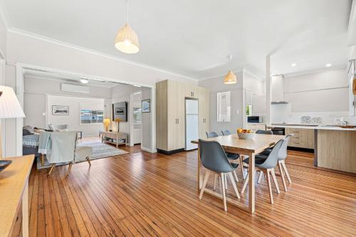 a kitchen and dining room with a table and chairs at Narooma Lighthouse Cottage - 74 Princes Highway Narooma in Narooma