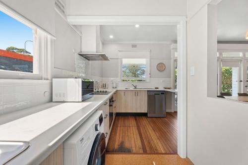 a kitchen with white counters and white appliances at Narooma Lighthouse Cottage - 74 Princes Highway Narooma in Narooma