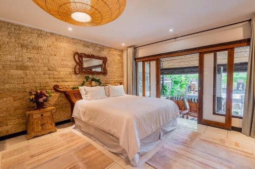 Peaceful Tranquil Villa in Nusa Dua في نوسا دوا: غرفة نوم بسرير ونافذة كبيرة