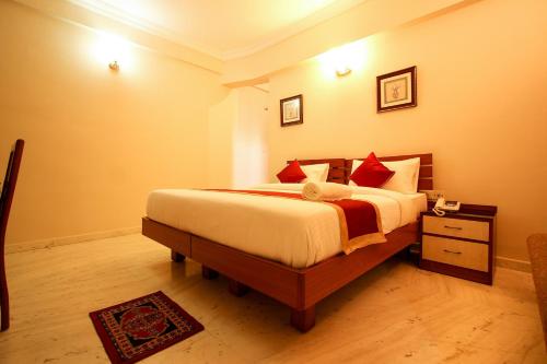 een slaapkamer met een groot bed met rode kussens bij OYO 6825 New Crescent Citadel in Bangalore