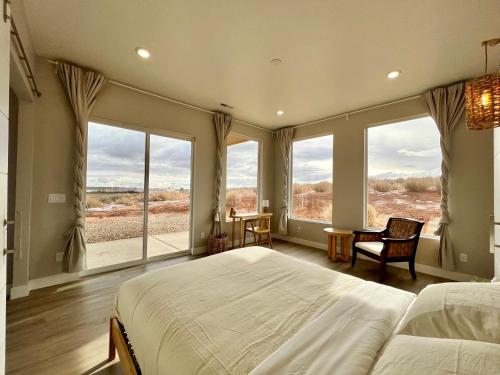 1 dormitorio con 1 cama grande y ventanas grandes en Tranquil Zen Retreat with Amazing Mesa Views, en Big Water