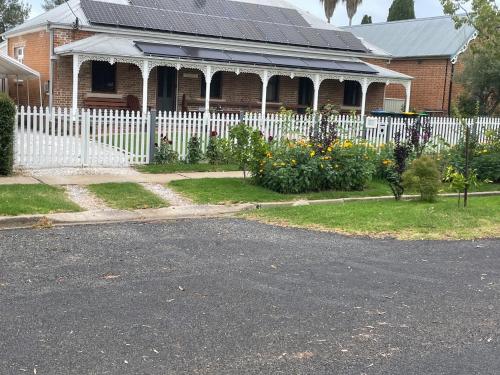 a white fence in front of a house at A Homestead on Market in Mudgee