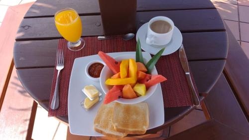 een bord met fruit en brood op een tafel bij Hotel La Pradera del Arenal in Fortuna
