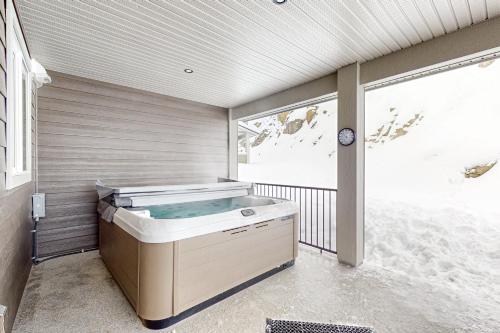 a jacuzzi tub in a room with a window at Bear Cave- Grizzly Ridge 260A in Big White
