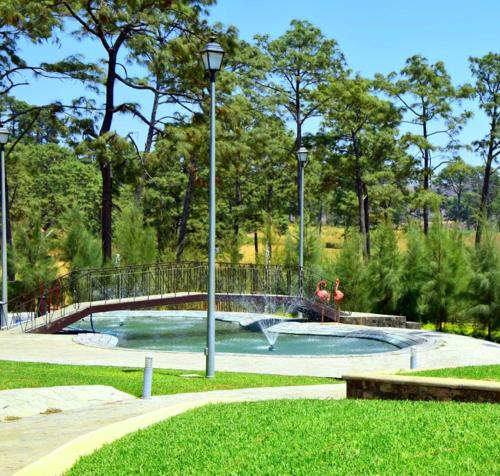 2 personnes jouant dans une piscine dans un parc dans l'établissement La ocotera hotel de montaña, à San Marcos