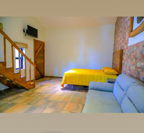 - un salon avec un canapé et un lit dans l'établissement La ocotera hotel de montaña, à San Marcos