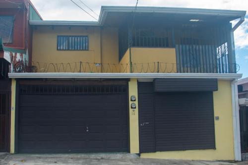 ein Haus mit einer Garagentür und einem Balkon in der Unterkunft Casa Calas in Alajuela