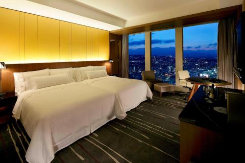 a large white bed in a room with a view at The Westin Sendai in Sendai