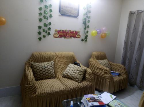 Habitación infantil con sofá y silla en Rent Room in Bashundhara R A near US Embassy en Dhaka