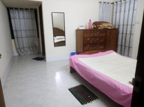 a bedroom with a bed and a dresser and a mirror at Rent Room in Bashundhara R A near US Embassy in Dhaka