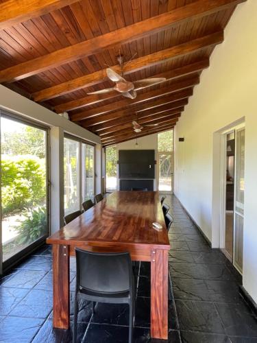a dining room with a wooden table and chairs at Quinta con piscina Laguna Sur Bitcoins House in Corrientes