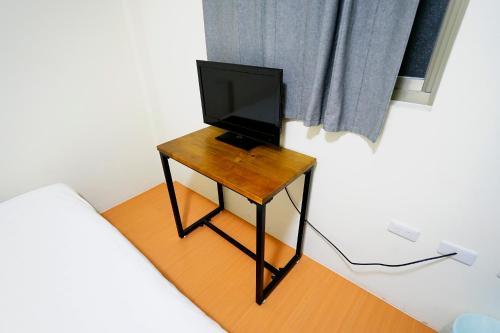 a television sitting on a table in a bedroom at 清芳民宿 Delicateperfume Hotel 瑞芳車站-九份 平溪 Juifen Pingxi in Ruifang