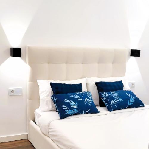 a white couch with three blue pillows on it at A1.0 - Alexa Smart house in Braga