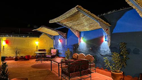 a patio with chairs and tables at night at Riad Dar Doura in Rabat