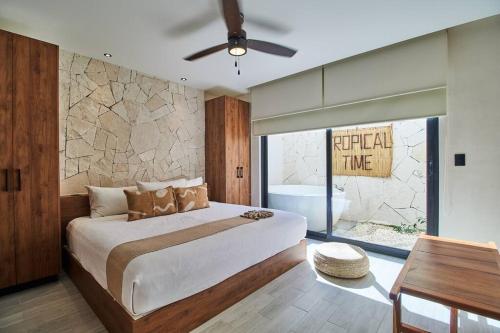een slaapkamer met een bed en een stenen muur bij Departamento en Tulum Jade in Tulum