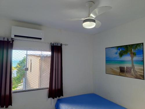 1 dormitorio con ventilador de techo y ventana en Apartamento 202 Peterle Irirí en Anchieta
