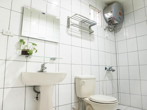 a white bathroom with a toilet and a sink at 清芳民宿 Delicateperfume Hotel 瑞芳車站-九份 平溪 Juifen Pingxi in Ruifang
