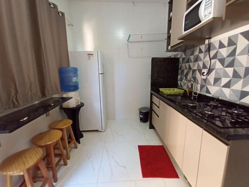 アンシエタにあるApartamento 202 Peterle Iriríのキッチン(冷蔵庫、スツール2台付)