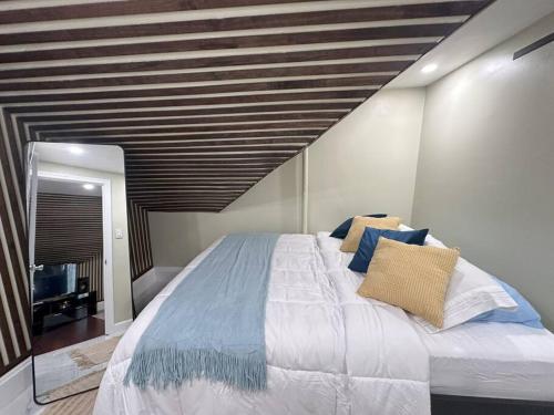 1 dormitorio con 1 cama grande con almohadas azules en Urban Life Retreat en Providence