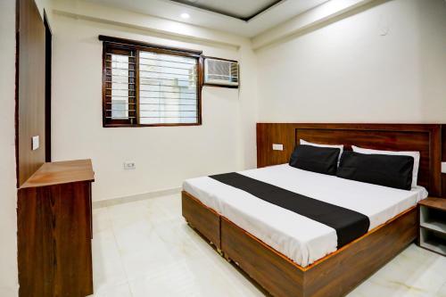 um quarto com uma cama e uma janela em Collection O Hotel Daffodil Inn em Gurgaon