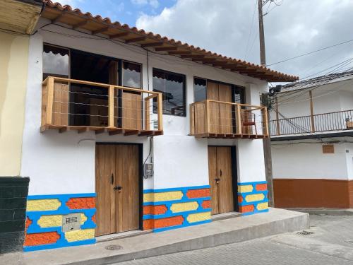 a colorful house with wooden doors and balcony at ApartaLoft Carolina in Carolina del Principe