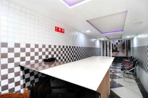 a bar in a restaurant with a checkered wall at Hotel O Max in Jalandhar